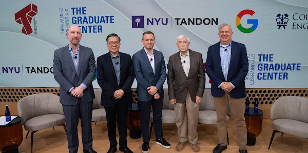 Five men in suits pose for a photo on a stage