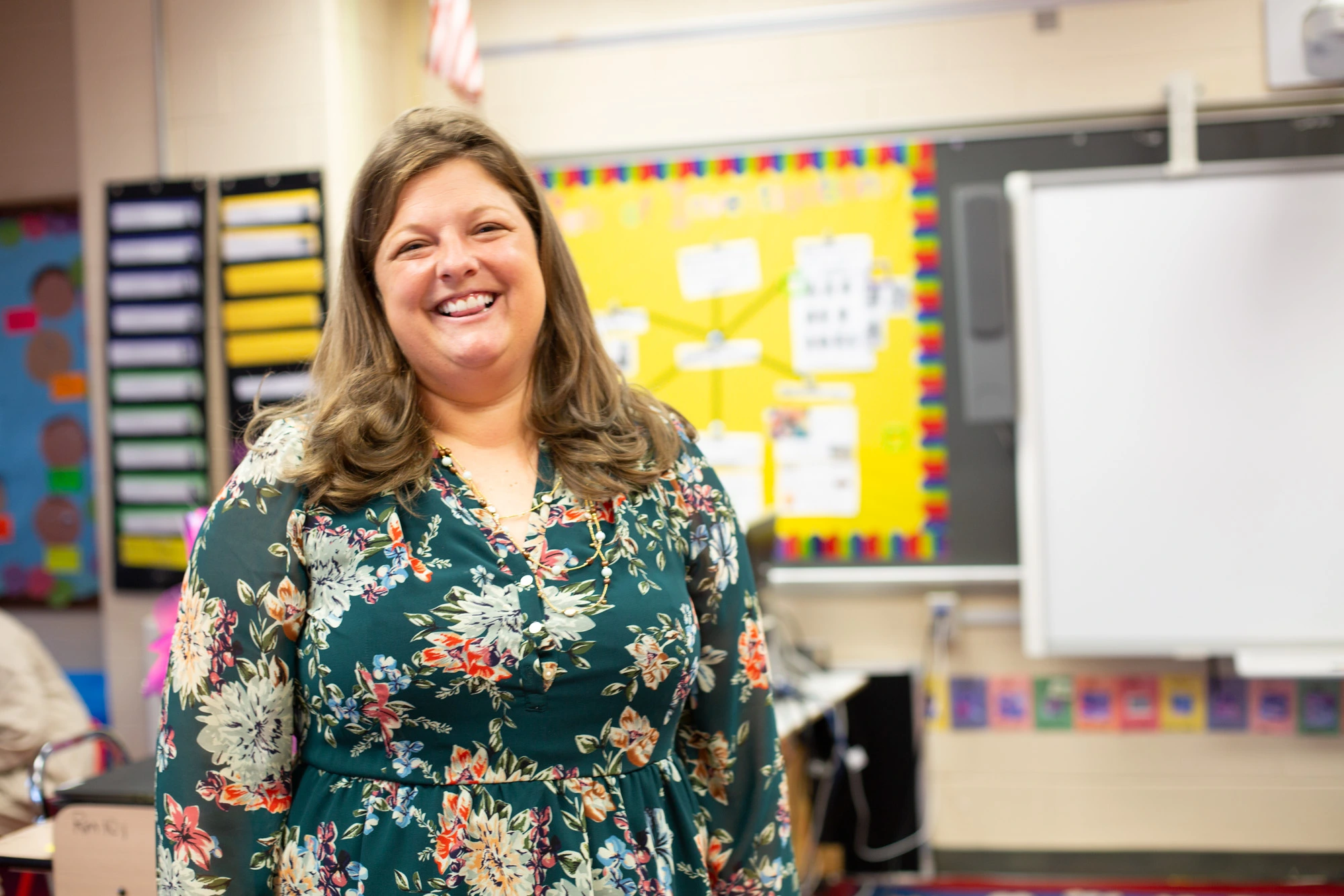 A happy teacher standing in their classroom