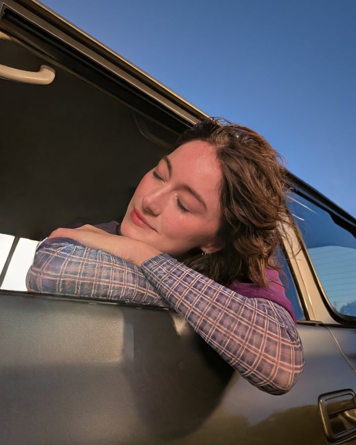 A person leaning their head out of a car window